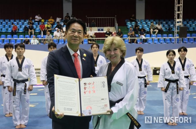 이동섭 국기원장(왼쪽)이 제인 넬슨 국무장관(오른쪽)에게 명예 5단증을 수여하고 기념사진을 촬영하고 있는 모습.