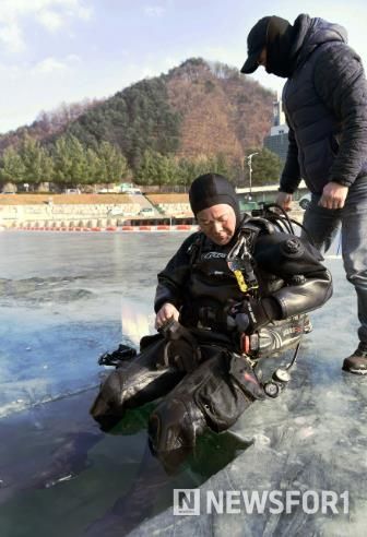 박영국 화천군 재난안전구조대 팀장이 물속 얼음판 상황을 점검하기 위해 잠수하고 있다